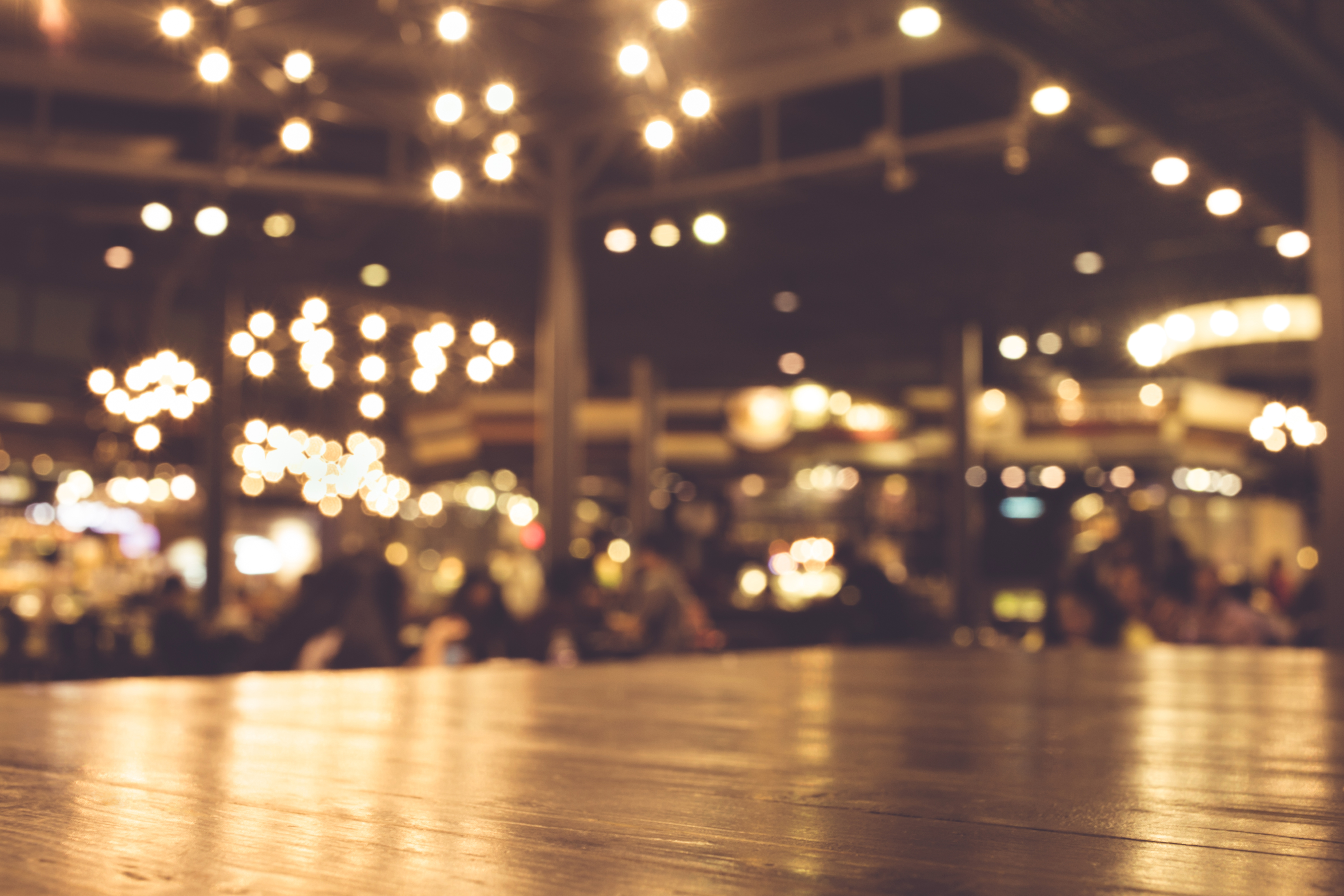 Wood table with blur of lighting in night cafe Rehab